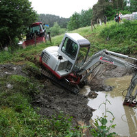 Bagger an einem mit Wasser gefüllten Graben